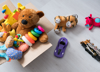 Des jouets colorés débordent d'une boîte.